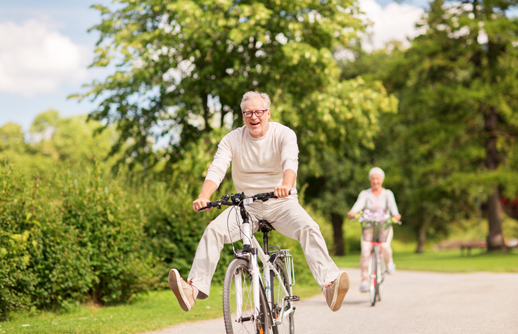 Ein älteres Paar auf dem Velo. Sie haben Spass.